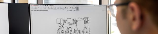 工程师在蓝图旁边用科学计算器进行结构受力计算，桌面摆放夏普计算器与数学手册，专业工作环境